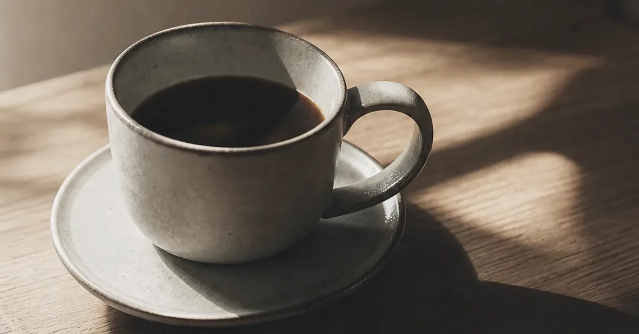 午後の光の中にあるコーヒーカップと小さな計量感